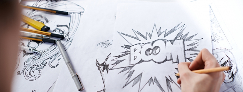 A comic book artist writing "BOOM" on a piece of paper