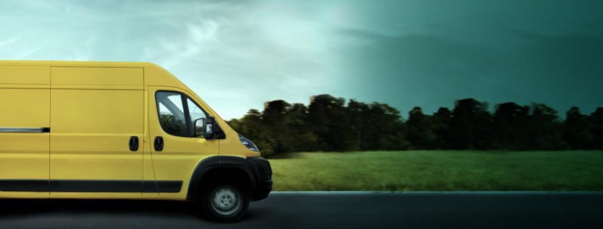Yellow commercial van driving towards a stormy road