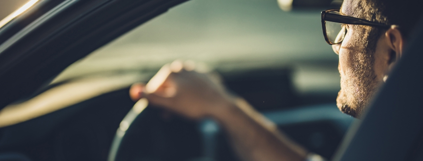 hands on a steering wheel of a car in motion