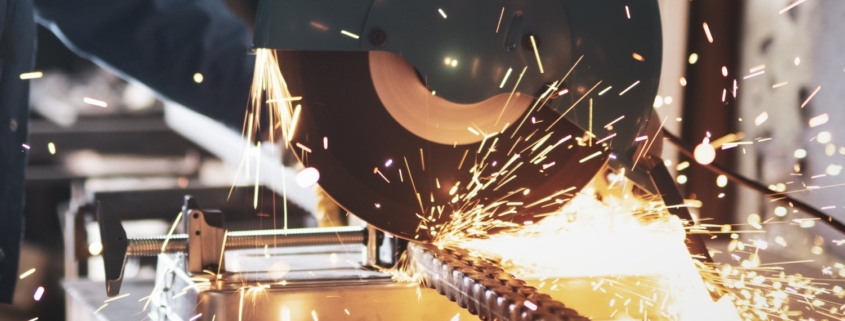 Sparks fly as mechanic uses electrical saw to cut through metal