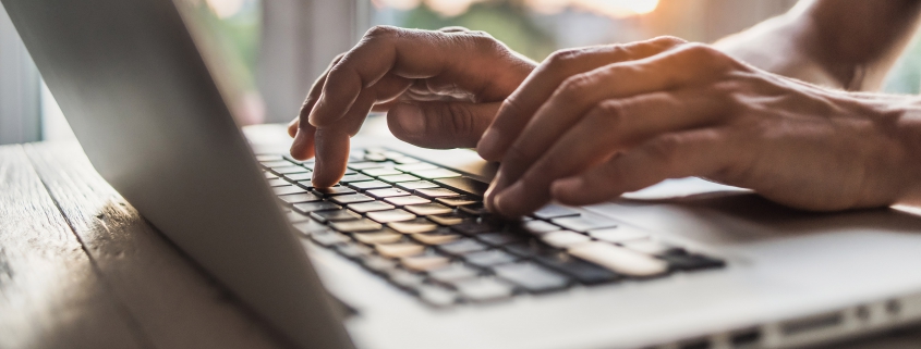 hands typing on laptop computer keyboard