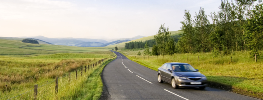 black car driving on road